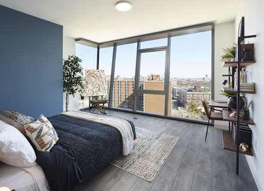 A bedroom with a large bed and a view of the city.