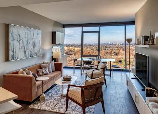 A living room with a couch, chairs, and a painting on the wall.