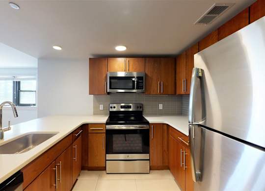 A modern kitchen with wooden cabinets and stainless steel appliances.
