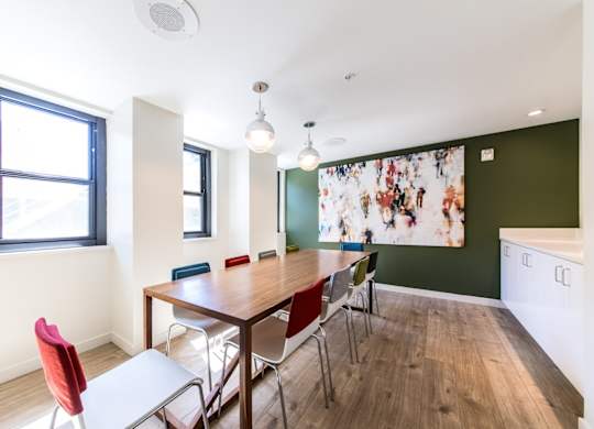 A dining room with a table and chairs.