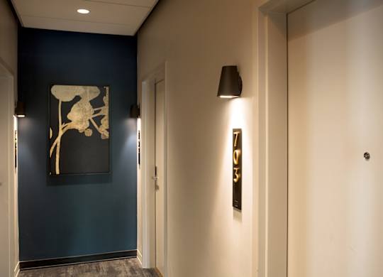 A hallway with a blue wall and a picture of a chair.