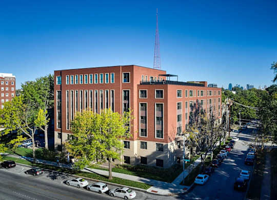 A red brick building with a tall antenna on the roof.