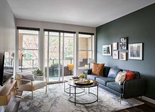 A living room with a black couch and a coffee table.