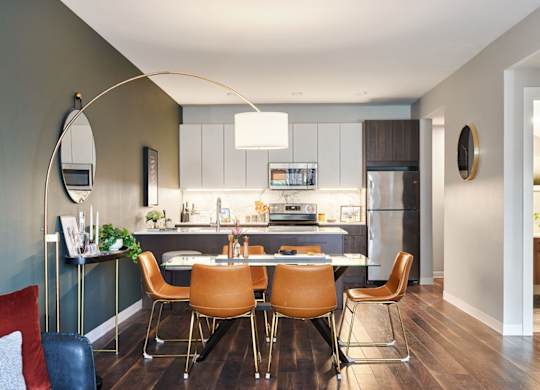 A modern kitchen with a dining table and chairs.