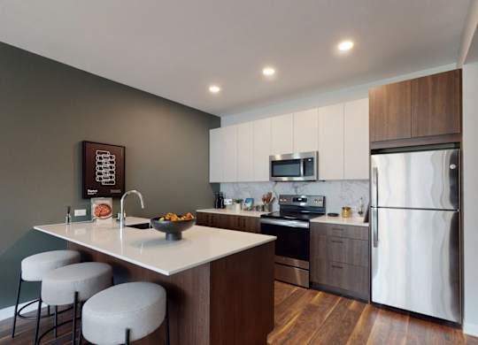 A modern kitchen with a white countertop and stainless steel appliances.