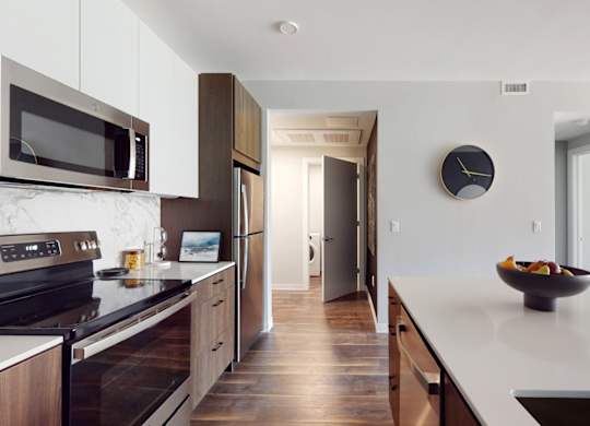 A modern kitchen with a bowl of fruit on the counter.