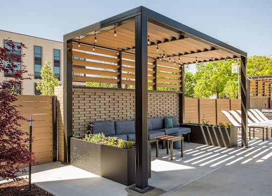 A patio with a table and chairs under a pergola.