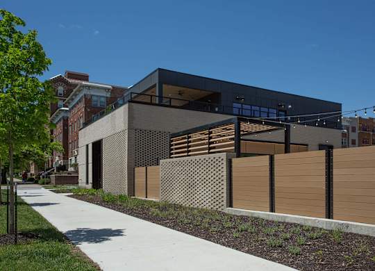 A modern building with a black facade and wooden fence.