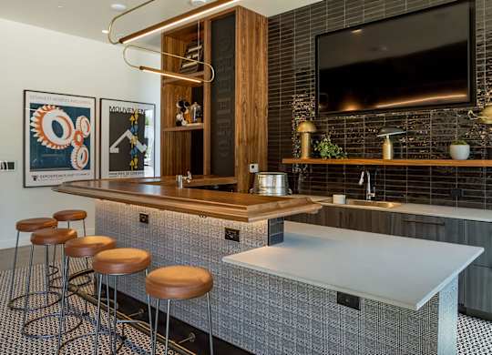 A modern kitchen with a bar area and a television above it.