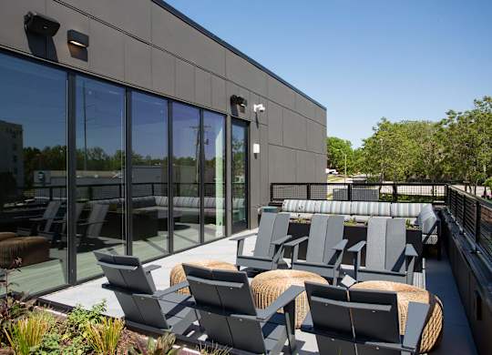 A modern patio with grey chairs and tables.