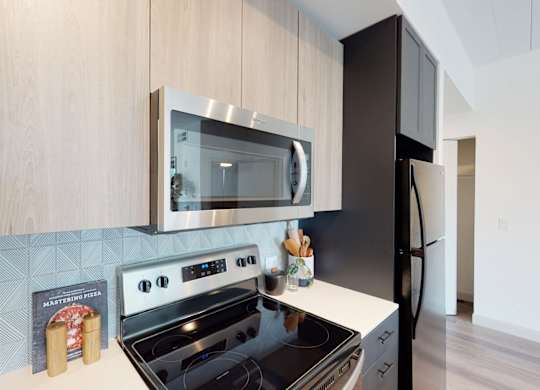 A modern kitchen with a black stove top oven and a black refrigerator.