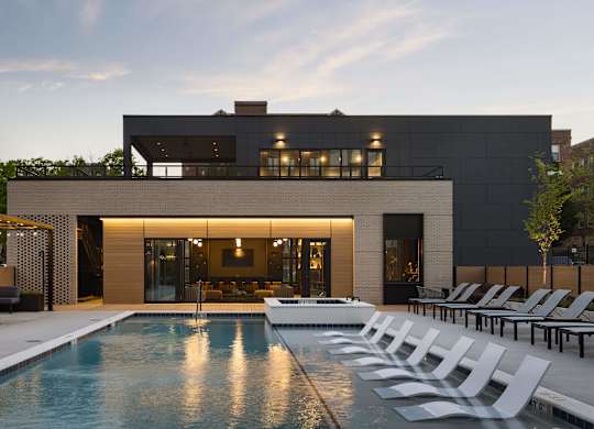 A modern house with a pool in front.