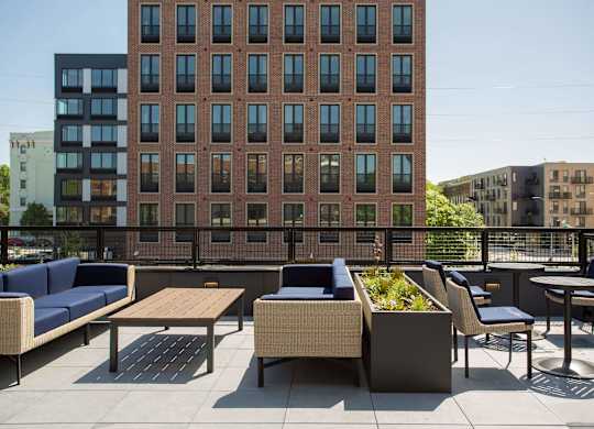 A patio with a table and chairs is in front of a brick building.