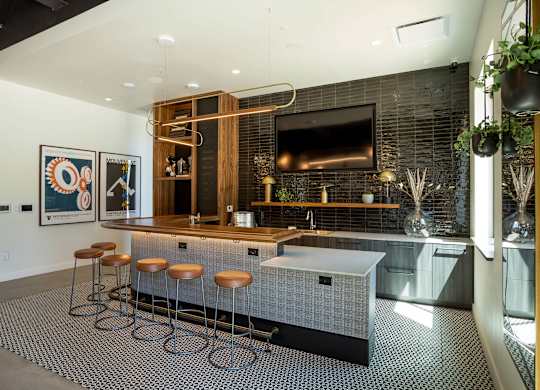 A modern kitchen with a bar area and stools.
