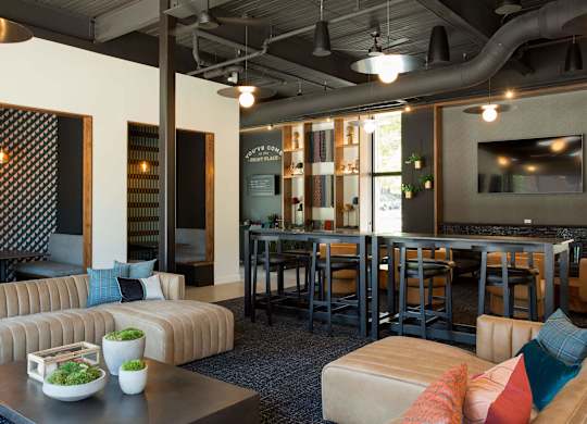 A modern living room with a sofa, coffee table, and a bar area.