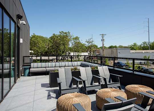 A patio with grey chairs and tables.