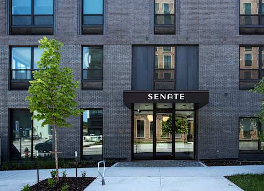 A modern building with a black awning that says "Senate" on it.