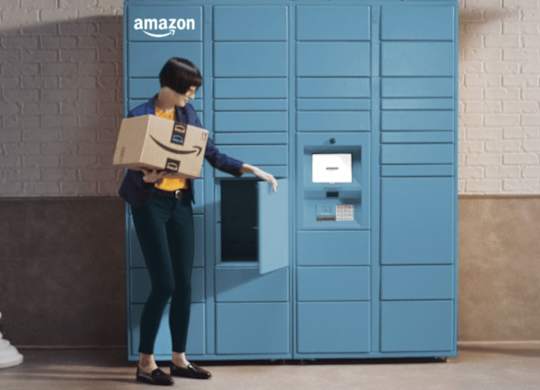 A person in a blue uniform is opening a blue Amazon locker.
