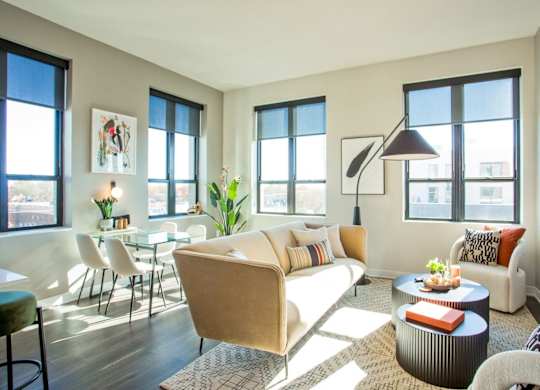 A living room with a sofa, chairs, and a table.