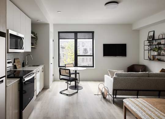 A modern kitchen with a dining area and a couch.