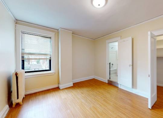 A room with a window and a radiator on the wall.