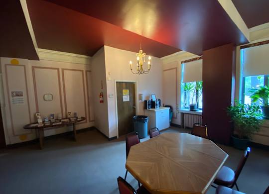 A dining room with a table and chairs.