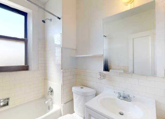 A white toilet sits next to a white sink in a bathroom.