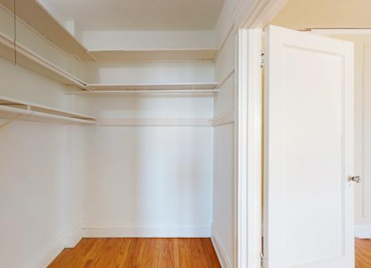 A white room with a wooden floor and a white door.