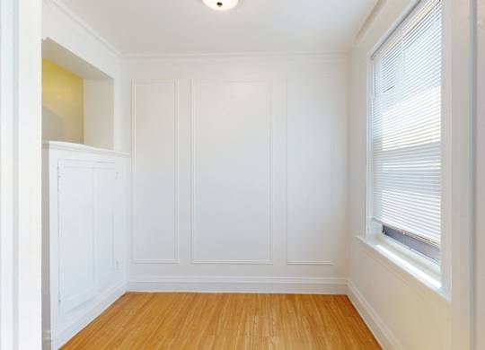 A room with white walls and wooden flooring.