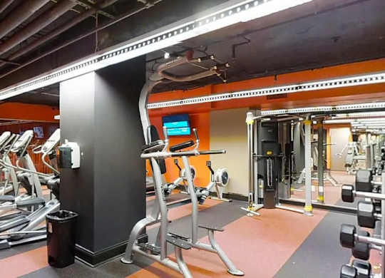 A gym with treadmills, weights, and exercise equipment.