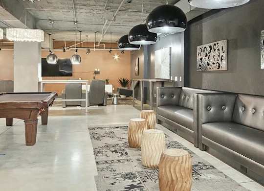 A room with a pool table and a couch.
