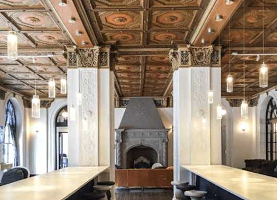 A room with a fireplace and a row of stools.