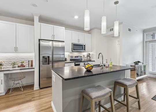 A modern kitchen with a large island and stools.