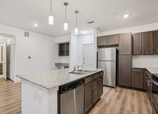 A kitchen with a granite countertop and stainless steel appliances.