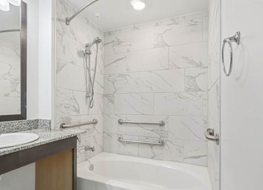 A white bathroom with a marble tile wall.