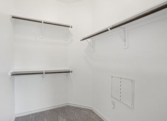 A white wall with a grey metal shelf.