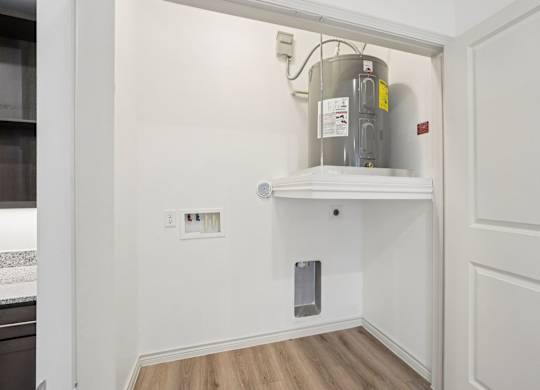 A kitchen with a white cabinet and a stainless steel pot on top.