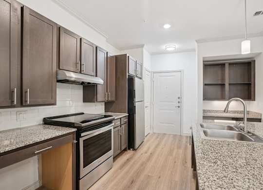 A kitchen with a granite counter top and stainless steel appliances.