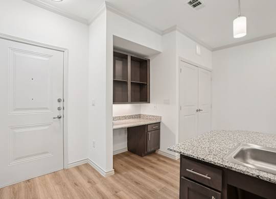 A kitchen with a sink, countertop, and cabinets.