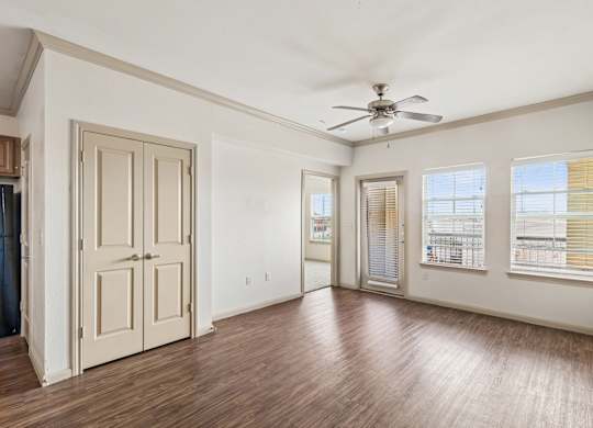 A room with a ceiling fan and wooden floors.