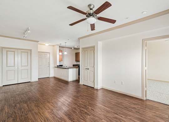 A room with a ceiling fan and wooden floors.