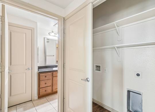 A white door is open to a kitchen and a hallway.