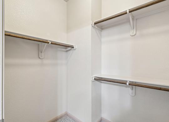 A white closet with two shelves and a door.