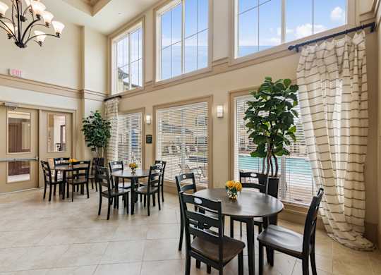 A dining room with a table set for six with a view of the pool outside.