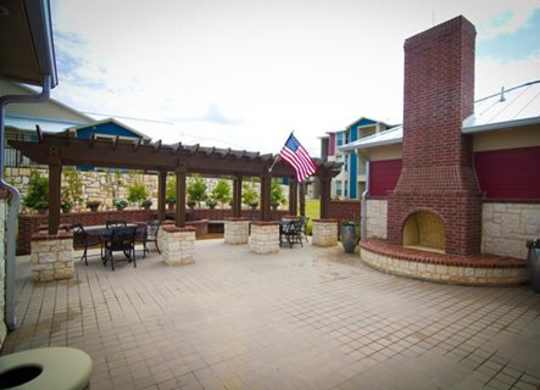 A patio with a brick chimney and a flag.