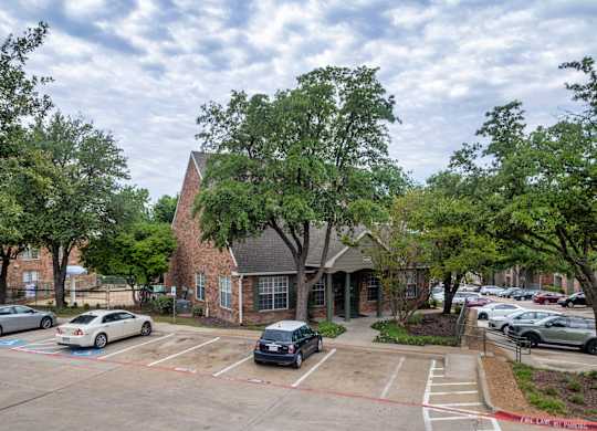 A parking lot with cars and a building in the background.