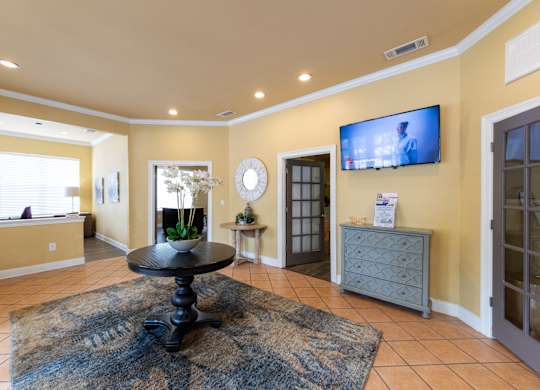 A living room with a black table in the middle of a rug.
