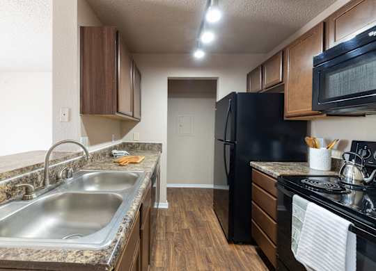 A kitchen with a black fridge and a black stove.