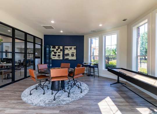 A room with a table and chairs in the middle of the room.