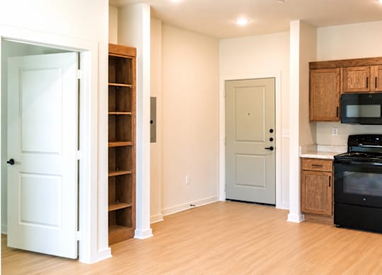A kitchen with a black stove top oven and wooden cabinets.
